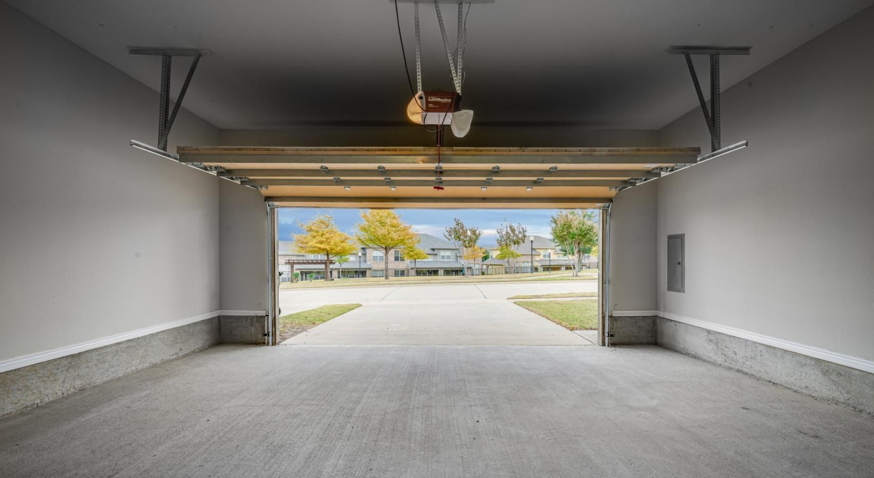 a concrete hallway with a view of a field and trees
