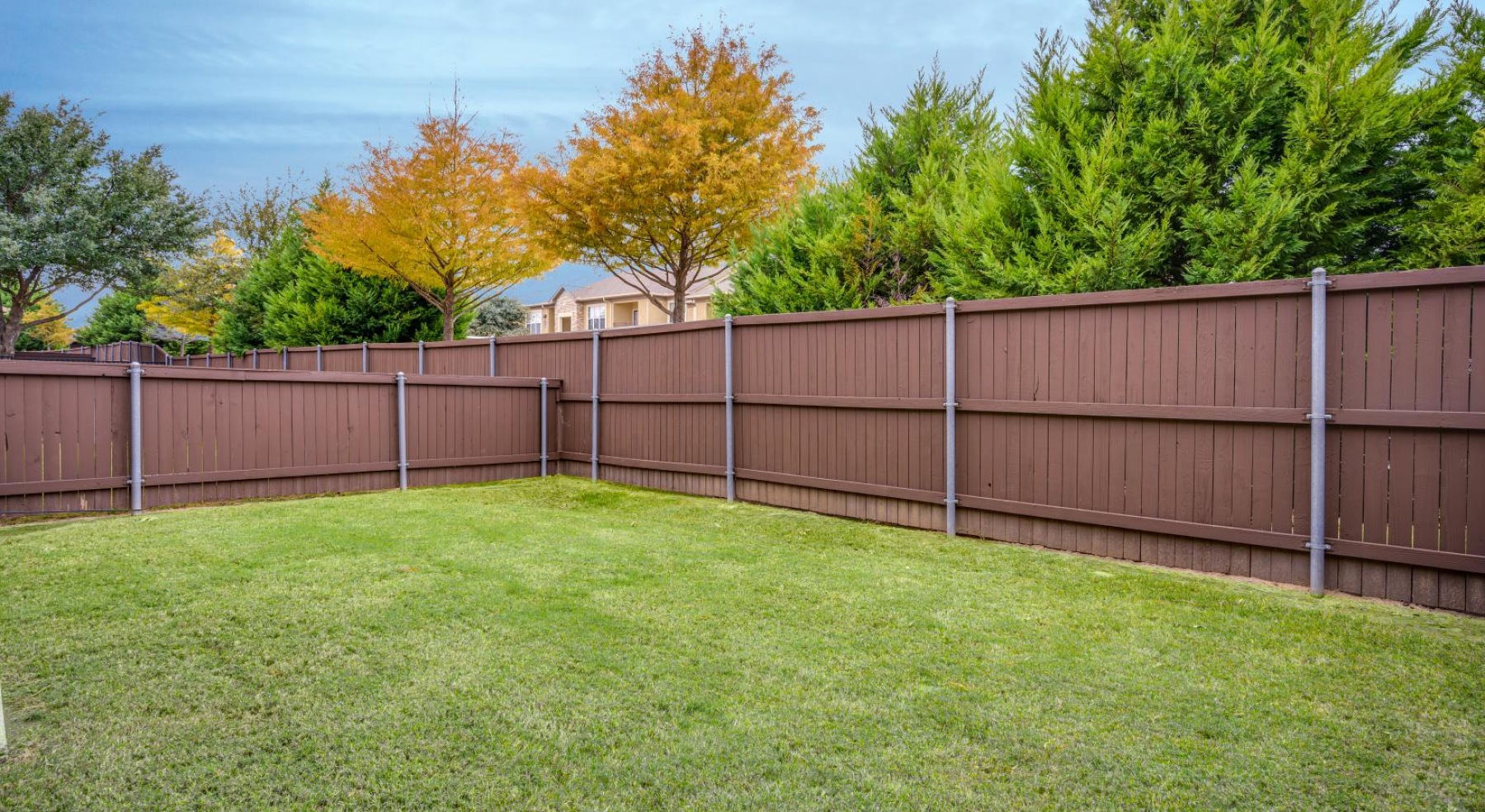 a fenced in yard with trees in the background