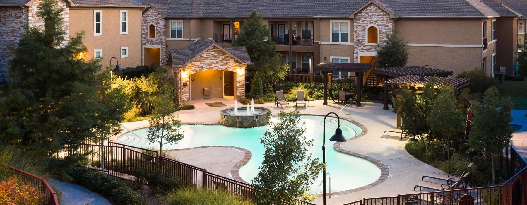 a backyard with a fountain and a house in the background